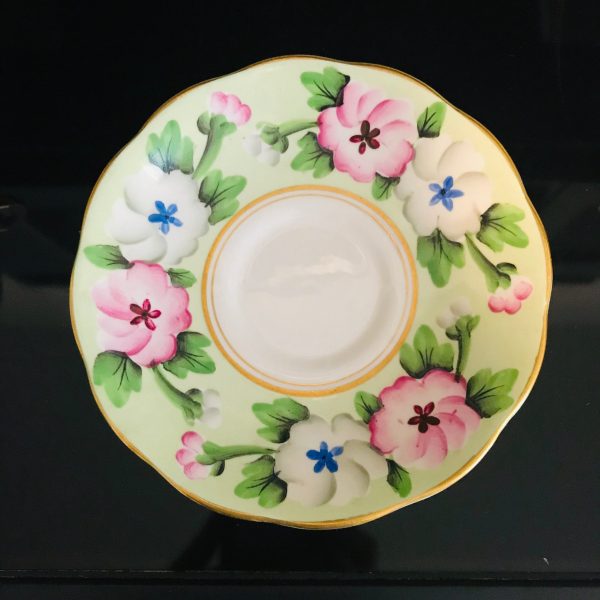 Royal Albert tea cup and saucer England Fine bone china Pink and white with blue centers Apple green background coffee display
