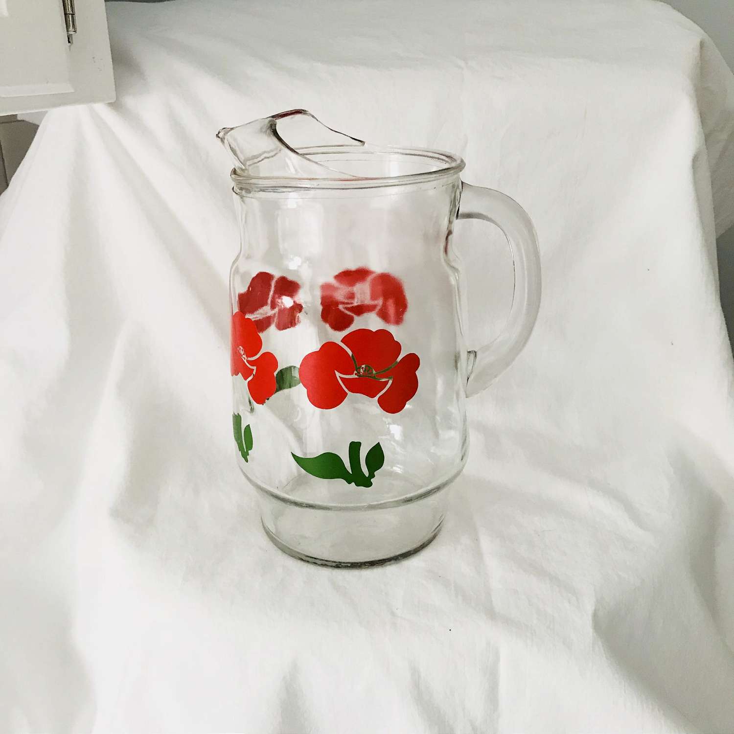 https://www.truevintageantiques.com/wp-content/uploads/2019/12/vintage-pitcher-glass-fired-on-paint-red-flowers-iced-tea-koolaid-collectible-retro-kitchen-display-farmhouse-summer-picnic-patio-water-5df9538e4-scaled.jpg