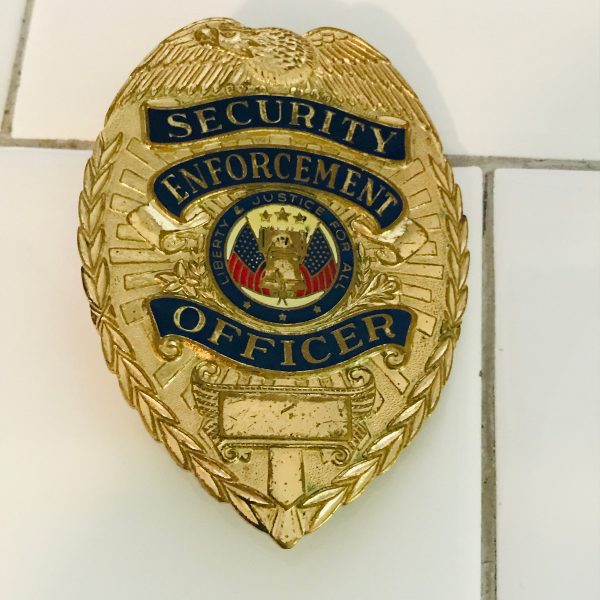 Obsolete Badge Security Enforcement Officer collectible display memorabilia gold red white blue shows wear Eagle top wreath sides