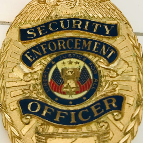 Obsolete Badge Security Enforcement Officer collectible display memorabilia gold red white blue shows wear Eagle top wreath sides