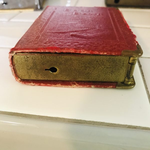 Vintage locking book bank made for storing money in a secret way metal with lock and leather binding Book Bank with money stacks raised