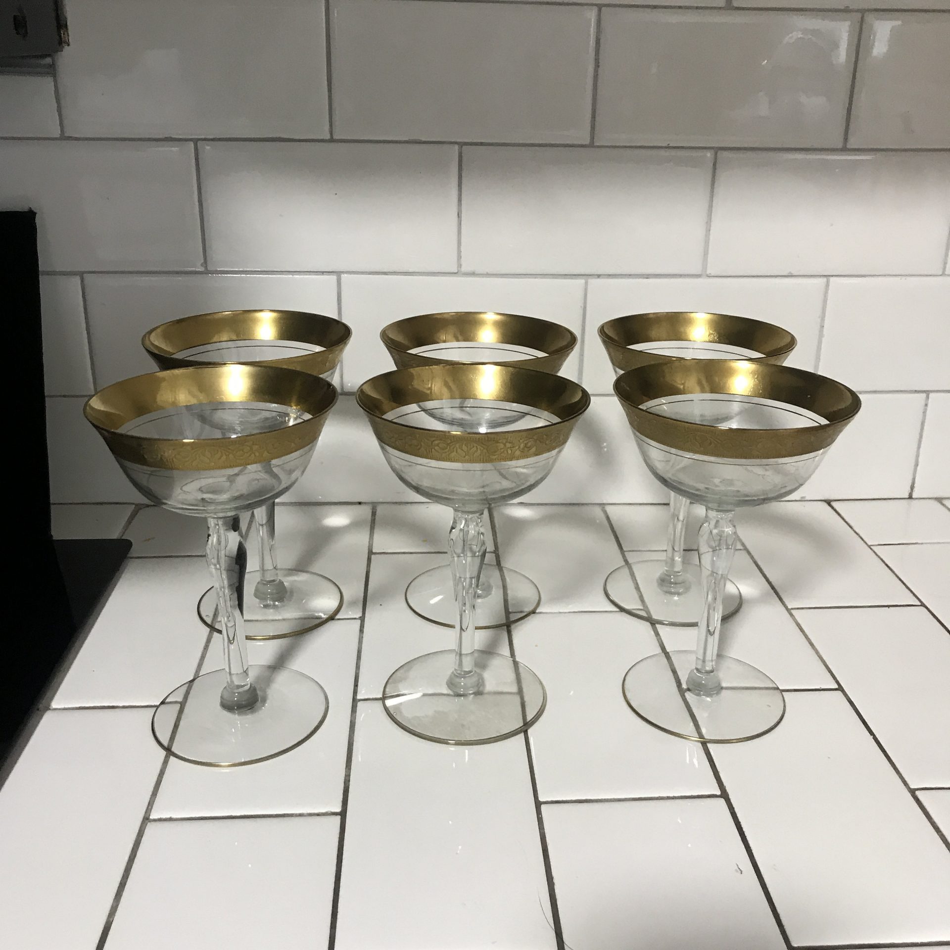 https://www.truevintageantiques.com/wp-content/uploads/2021/05/vintage-set-of-6-wine-glasses-shallow-champagne-paneled-crystal-with-heavy-gold-ornate-trim-display-collectible-evening-dining-609909551-scaled.jpg